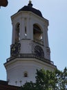 The upper tier of the Clock Tower, a former bell tower with a dome, clock and weather vane against the blue sky