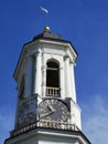 The upper tier of the Clock Tower, a former bell tower with a dome, clock and weather vane against the blue sky