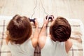 Upper view of couple in love playing video games with joysticks on the bed Royalty Free Stock Photo