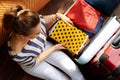 Elegant woman putting stuff in open travel suitcase