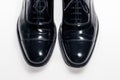 Upper View of Pair of Formal Male Stylish Black Polished Oxford Leather Laced Shoes Placed Together Over White