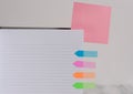 Upper view striped lined hard cover note book blank color sticky note arrow banners inserted clear background. Reminder Royalty Free Stock Photo