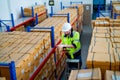 Upper view warehouse worker man stand on stair and hold tablet to check product on shelves in workplace