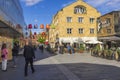 Uppsala downtown cityscape view. Colorful lamps decorating pass between buildings. People enjoy warm weather. Sweden.