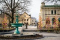 UPPSALA, SWEDEN - Mar 26, 2016 - View of inactive fountain with traditional colourful feathers on trees for Easter decor