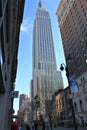 Upright shot of Empire State building seen from ground level, squeezed between two buildings