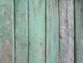 Upright striped wooden wall, fence, background with old threadbare green paint