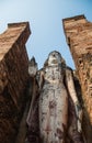 Uprisen angle view of old stand buddha statue in the ancient temple Thailand