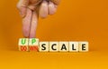 Upscale or downscale symbol. Concept words Upscale or Downscale on wooden cubes. Beautiful orange table orange background.