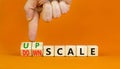 Upscale or downscale symbol. Concept words Upscale or Downscale on wooden cubes. Beautiful orange table orange background.