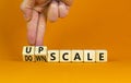 Upscale or downscale symbol. Concept words Upscale or Downscale on wooden cubes. Beautiful orange table orange background.