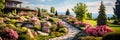 Upscale home garden in summer, luxury design of landscaped house backyard. Panoramic view of path, flowers, terrace and plants at Royalty Free Stock Photo