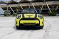 Upscale yellow car with black stripes and stylish round headlamps. Convertible Mini Cooper standing with roof off and Royalty Free Stock Photo