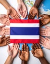 diverse group of hands surrounding the flag of Thailand, symbolizing unity and cultural representation on a world map backdrop. Royalty Free Stock Photo