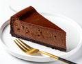 rich chocolate cheesecake slice on a white plate with a gold fork, showcasing its smooth texture and dark crust. Royalty Free Stock Photo