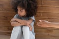 Upset african american little girl ignoring lent mommys hand.