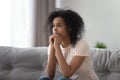 Upset African American woman thinking about problem at home alone