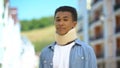 Upset afro-american teen boy in foam cervical collar sadly sighing on cam trauma Royalty Free Stock Photo