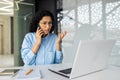 Upset and angry female boss at workplace inside office, frustrated businesswoman talking on phone, Hispanic woman inside Royalty Free Stock Photo