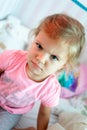 Angry little girl sitting on a bed.