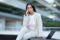 Upset arabic businesswoman talking on phone sitting with laptop outside Royalty Free Stock Photo