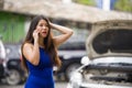 Upset Asian Chinese woman in stress stranded on street suffering car engine failure having mechanic problem calling on mobile Royalty Free Stock Photo