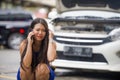 Upset Asian Japanese woman in stress stranded on street suffering car engine failure having mechanic problem calling on mobile Royalty Free Stock Photo