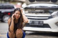 Upset Asian Korean woman in stress stranded on street suffering car engine failure having mechanic problem calling on mobile phone Royalty Free Stock Photo