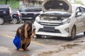 Upset Asian Korean woman in stress stranded on street suffering car engine failure having mechanic problem calling on mobile phone Royalty Free Stock Photo