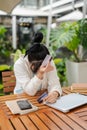 A upset Asian woman hand covering her face while holding a credit card, having financial problems Royalty Free Stock Photo