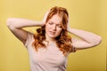 Upset beautiful young woman with red hair holds hands to her head. Royalty Free Stock Photo