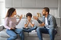 Upset black boy sitting with hands on cheeks while his parents argue Royalty Free Stock Photo