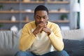 Upset black man having problems, sitting on couch at home Royalty Free Stock Photo