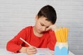Upset boring schoolboy doing homework. Education, school, learning difficulties concept Royalty Free Stock Photo