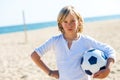 Upset boy holding soccer ball outdoors.