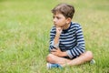 Upset boy sitting on grass Royalty Free Stock Photo
