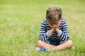 Upset boy sitting on grass Royalty Free Stock Photo