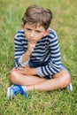 Upset boy sitting on grass Royalty Free Stock Photo