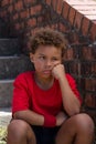 Upset boy sitting on staircase in the boot camp Royalty Free Stock Photo