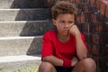 Upset boy sitting on staircase in the boot camp Royalty Free Stock Photo
