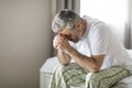 Upset broken middle aged man sitting on bed at home Royalty Free Stock Photo