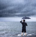 Upset business man holding a umbrella with cloudburst Royalty Free Stock Photo