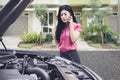 Upset business woman talking on the phone asking for a mechanic help to fix broken down car Royalty Free Stock Photo