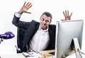 Upset businessman having a corporate tantrum at his computer desk