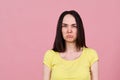 Upset by the caricature of a sad brunette girl in yellow shirt, makes a face and sticks out lower lip. Large Studio portrait Royalty Free Stock Photo