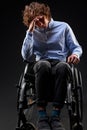 upset caucasian male sits on wheelchair with head bowed