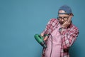 Upset Caucasian man looks at his broken electric drill and wonders what to do. Home repairs. Copy space. Blue background