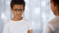 Upset child in eyeglasses looking mirror reflection, blurry vision, insecurities Royalty Free Stock Photo