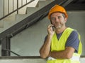 Upset construction worker or stressed contractor man in hardhat and vest talking on mobile phone unhappy in stress messing with Royalty Free Stock Photo