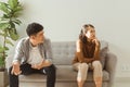 Upset couple at home. Handsome man and beautiful young woman are having quarrel. Sitting on sofa together. Family problems Royalty Free Stock Photo